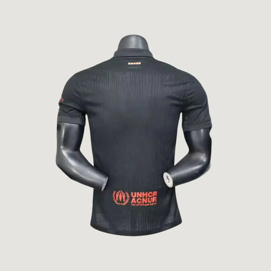 Maillot de foot noir homme vu de dos, logo UNHCR rouge, manches courtes, col polo.