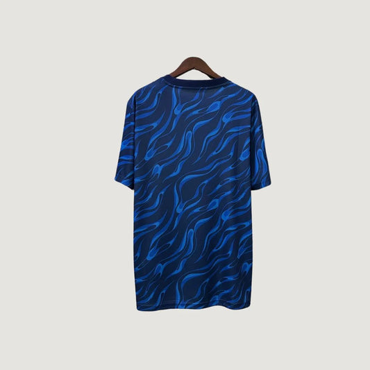 Maillot de foot bleu motif flammes, vue dos, suspendu sur cintre, style tendance.