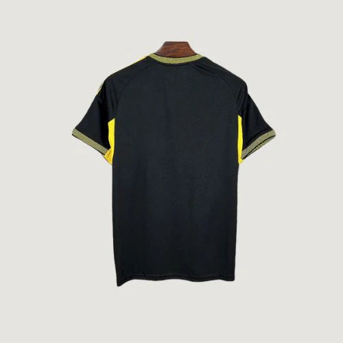 Maillot de foot noir avec détails jaunes, vu de dos, style moderne, manches courtes.