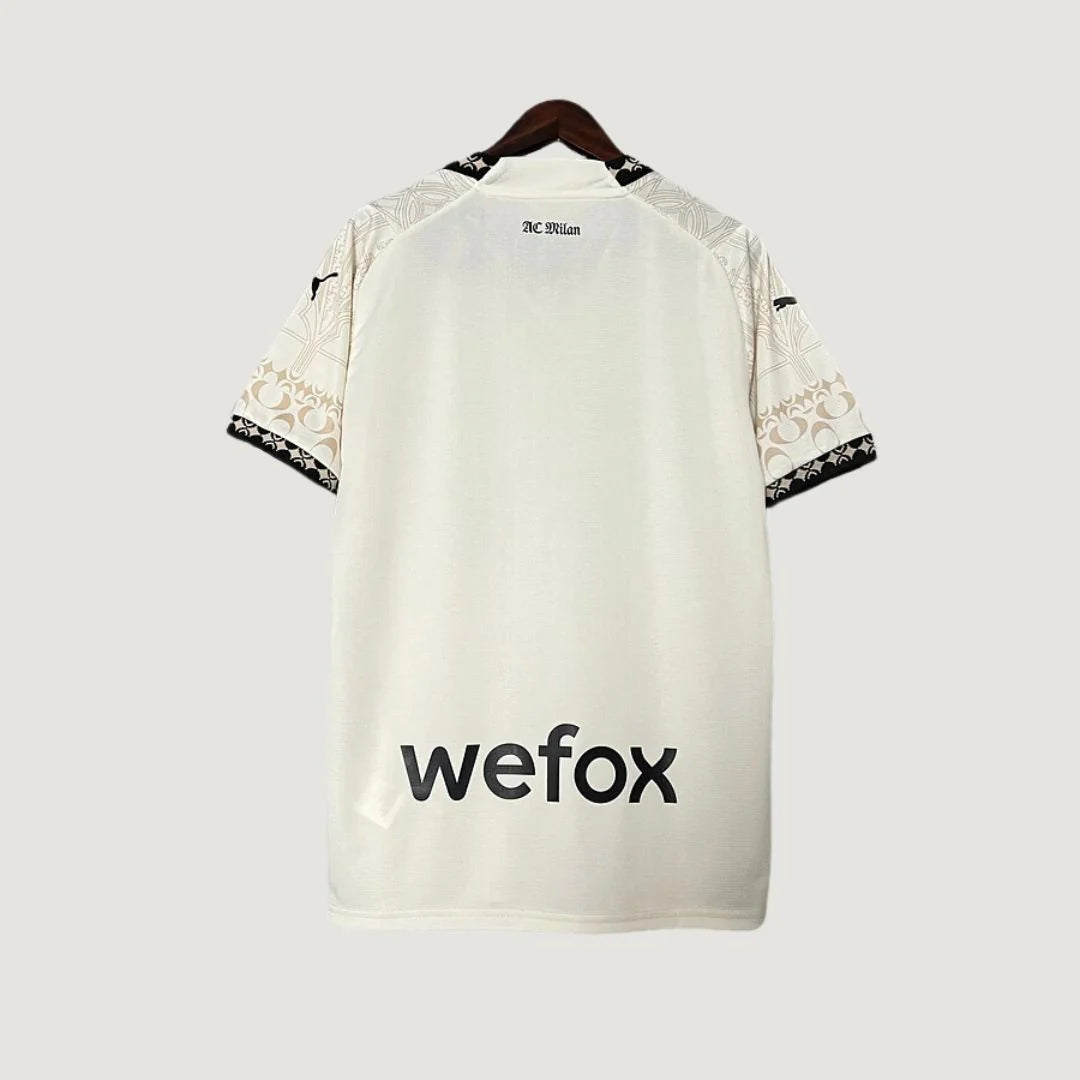 Maillot de foot blanc dos, manches motifs beige, texte AC Milan et sponsor wefox visible.
