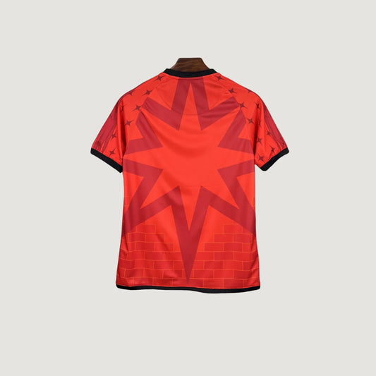 Maillot de football rouge design étoile et motif brique, dos du t-shirt visible sur fond clair.
