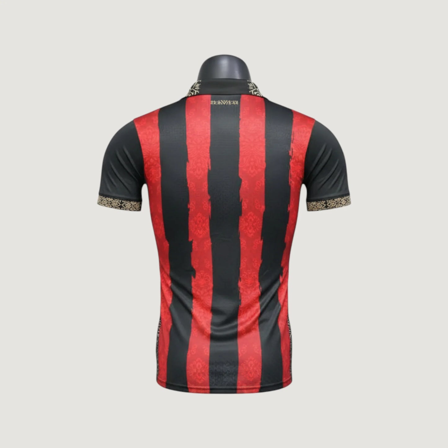 Maillot de foot homme noir à rayures rouges, col et manches à motif doré, dos visible.