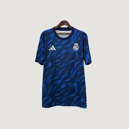 Maillot de foot bleu à motifs ondulés, logo du club et logo Adidas sur le torse.