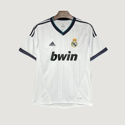 Maillot de foot blanc Adidas Real Madrid avec logo, sponsor bwin, col en V et détails noirs.