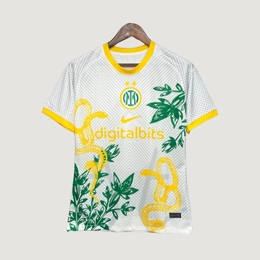 Maillot de foot blanc avec motifs serpent jaune et feuillage vert, logo Nike et détails jaunes.