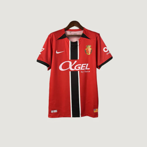 Maillot de foot rouge avec bandes noires et blanches, logo Nike et écusson club brodé.