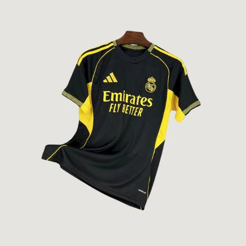 Maillot de football noir et jaune avec logos brodés, manches courtes, style Réal Madrid.