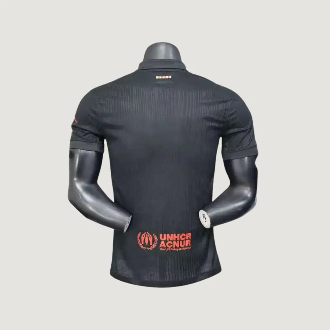 Maillot de foot noir homme vu de dos, logo UNHCR rouge, manches courtes, col polo.