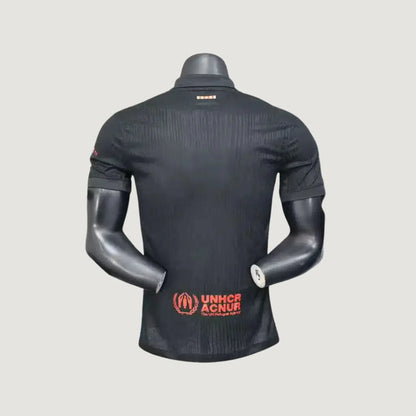 Maillot de foot noir homme vu de dos, logo UNHCR rouge, manches courtes, col polo.