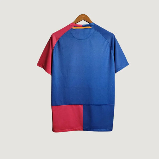 Maillot de foot bicolore bleu et rouge, manche courte, vu de dos sur cintre.