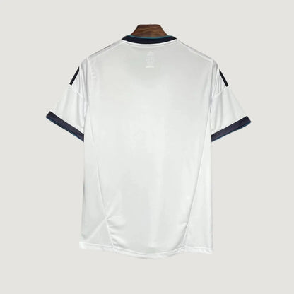 Dos d’un maillot de football blanc à manches courtes, liserés noirs, sur fond uni.
