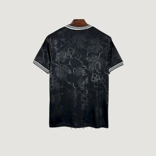 Maillot de foot noir motif floral ton sur ton, dos visible, col et manches rayés.