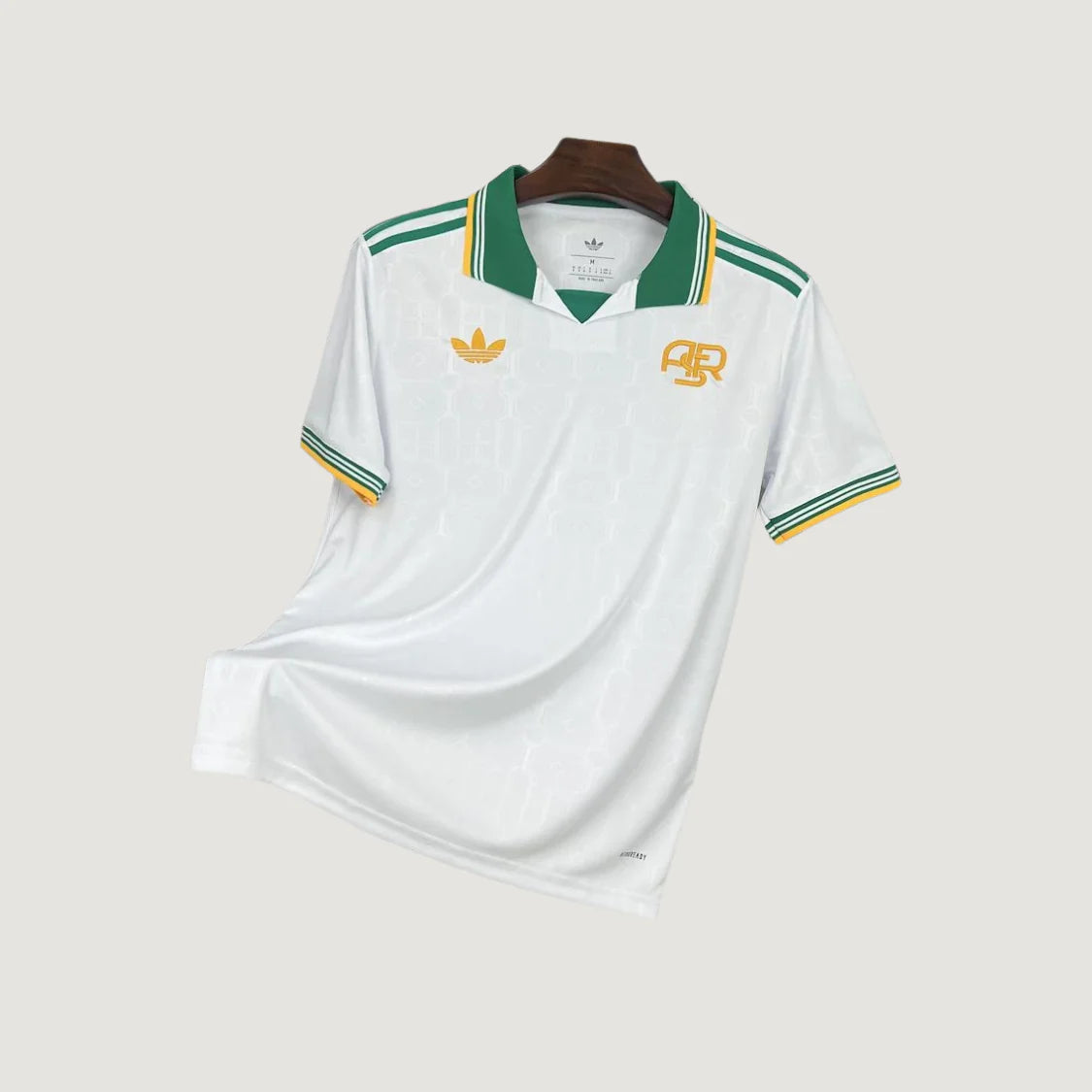 Maillot de foot blanc à col vert, détails jaunes et verts, style rétro, manches courtes.