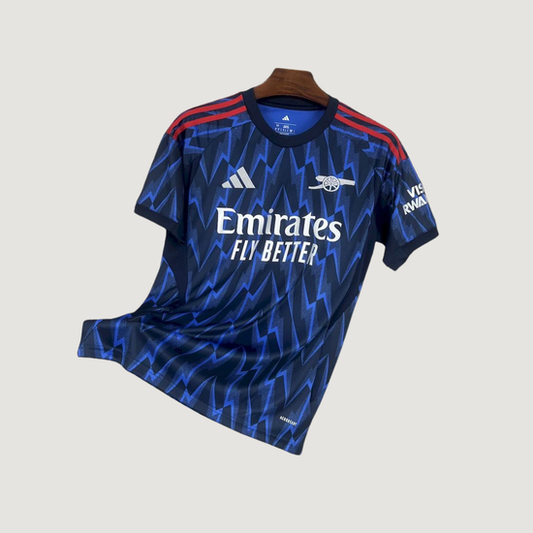 Maillot de foot bleu motif éclairs, bandes rouges sur les épaules, logo Emirates, manches courtes