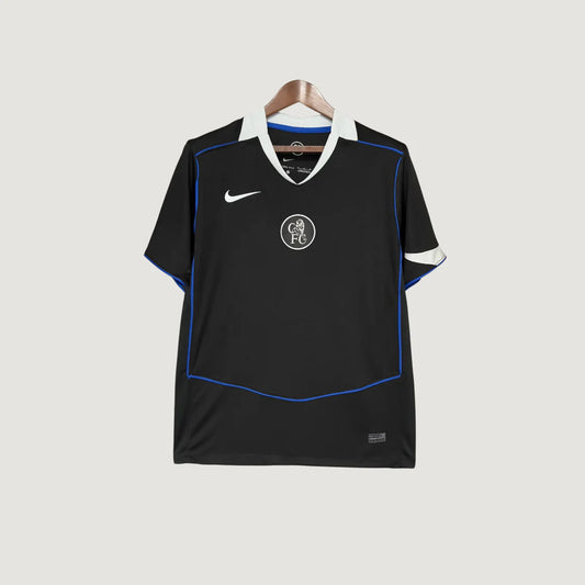 Maillot de foot noir homme, logo CFC, détails bleus et blancs, suspendu sur cintre.