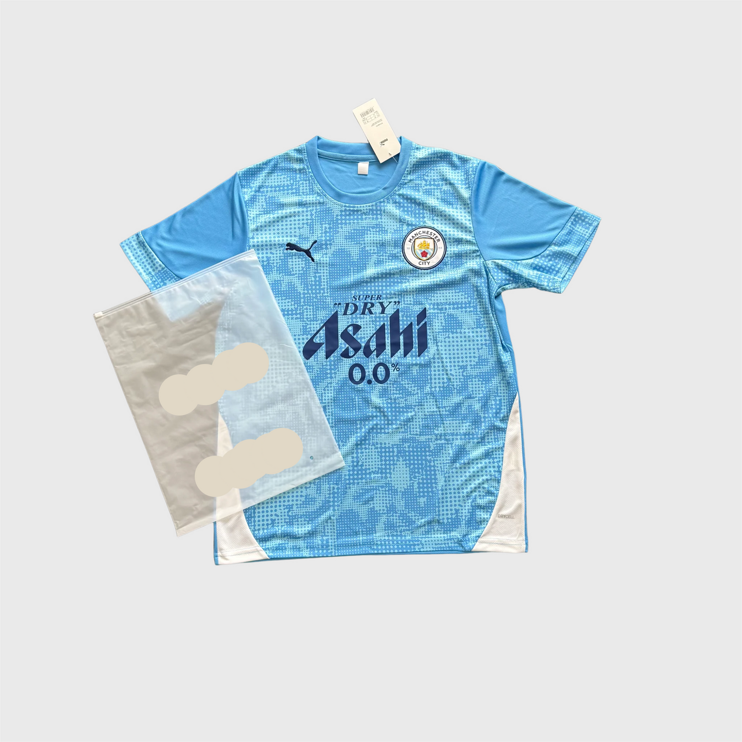 Maillot de foot bleu manches courtes avec écusson et sponsor, emballage à côté.