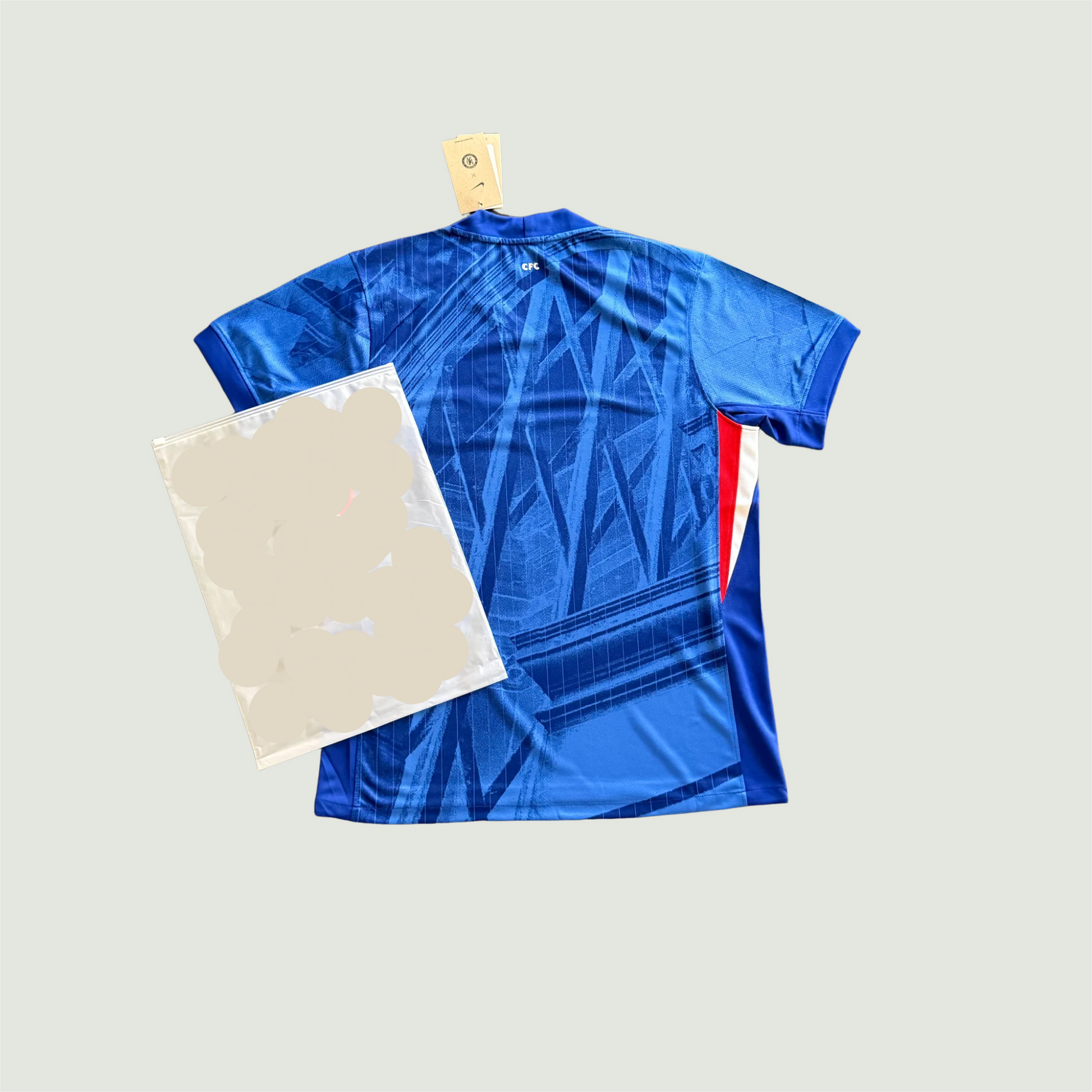 Maillot de foot bleu motif graphique vu de dos, détails rouges et blancs sur le côté.
