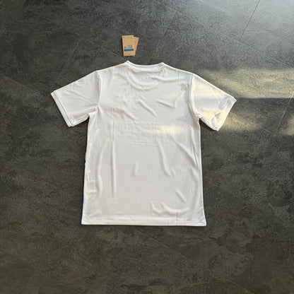Maillot de foot blanc uni vu de dos, posé au sol, étiquette visible