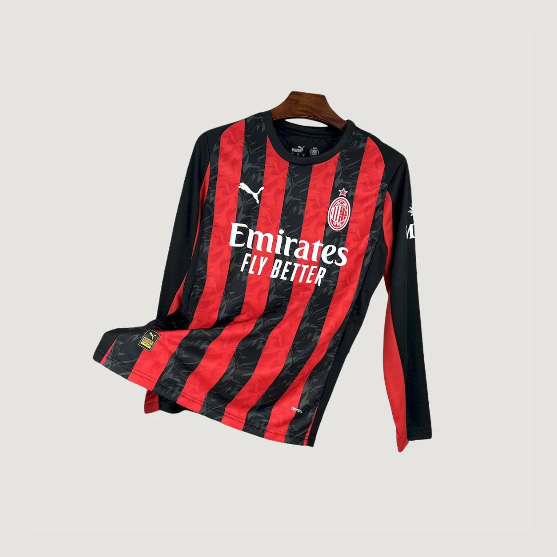 Maillot de foot manches longues rouge et noir à rayures, logo sponsor et écusson.