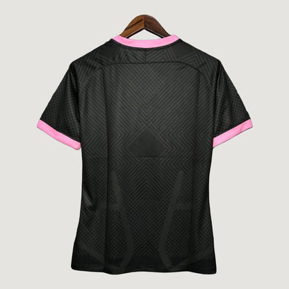 Maillot de football noir avec motifs géométriques et détails roses, vu de dos