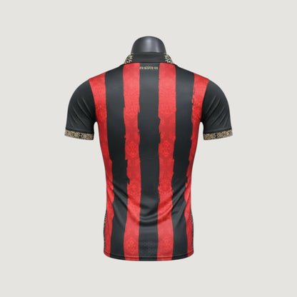 Maillot de foot homme noir à rayures rouges, col et manches à motif doré, dos visible.